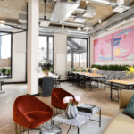Modern coworking space with stylish furniture, natural light, and vibrant decor.