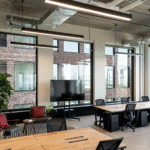 Modern coworking space in Singapore with wooden desks, ergonomic chairs, and large windows.