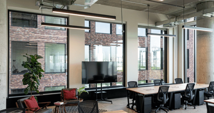 Modern coworking space in Singapore with wooden desks, ergonomic chairs, and large windows.