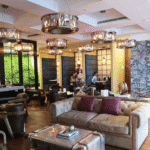 Cozy lounge area with leather sofas, artistic decor, and warm lighting in a stylish coworking space.