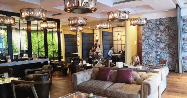 Cozy lounge area with leather sofas, artistic decor, and warm lighting in a stylish coworking space.